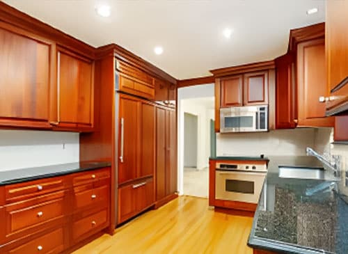 A Large Kitchen With Stainless Steel Appliances And Wooden Cabinets