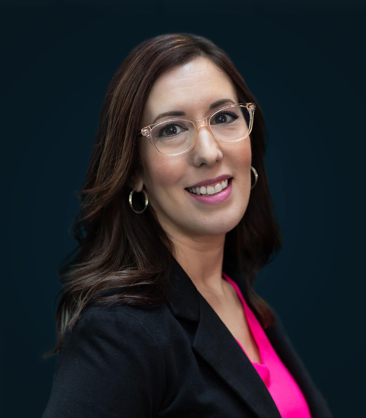 a woman wearing glasses and smiling at the camera