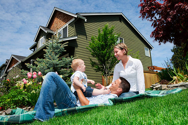 young couple with child next to house