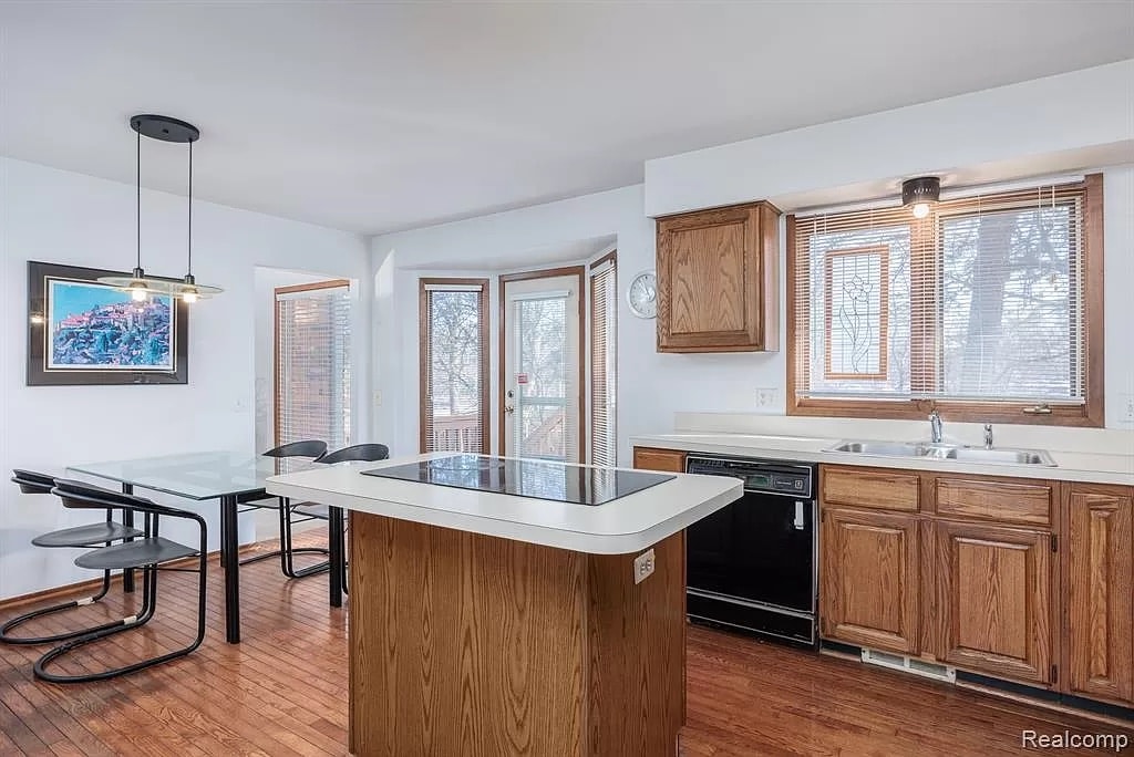 a kitchen with wooden cabinets and a wood floor